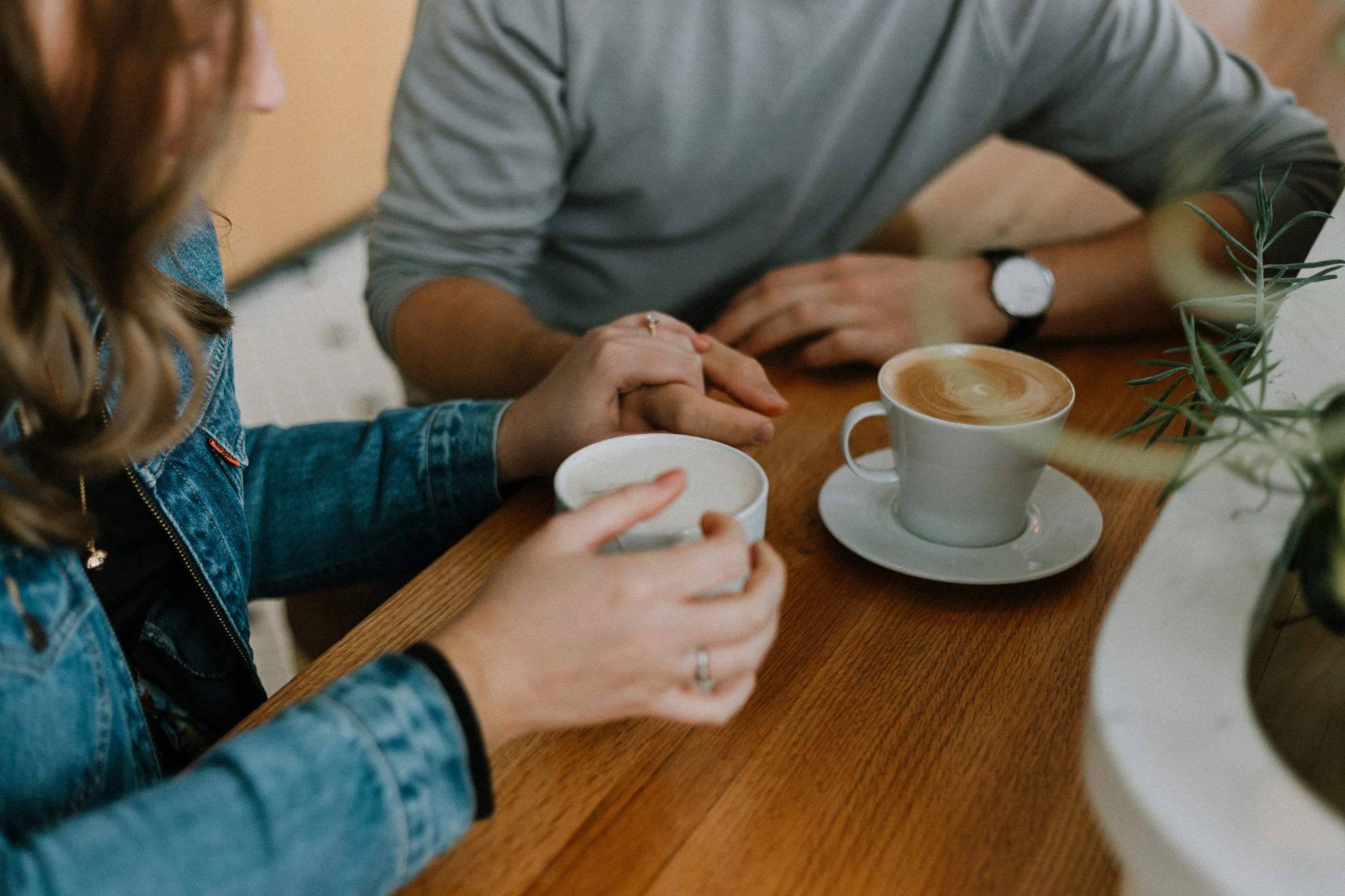Hands held across a café table